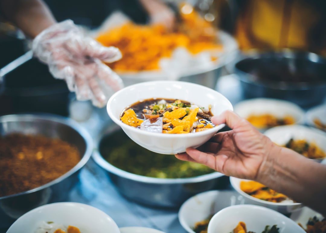 Hands sharing food in a community kitchen.
