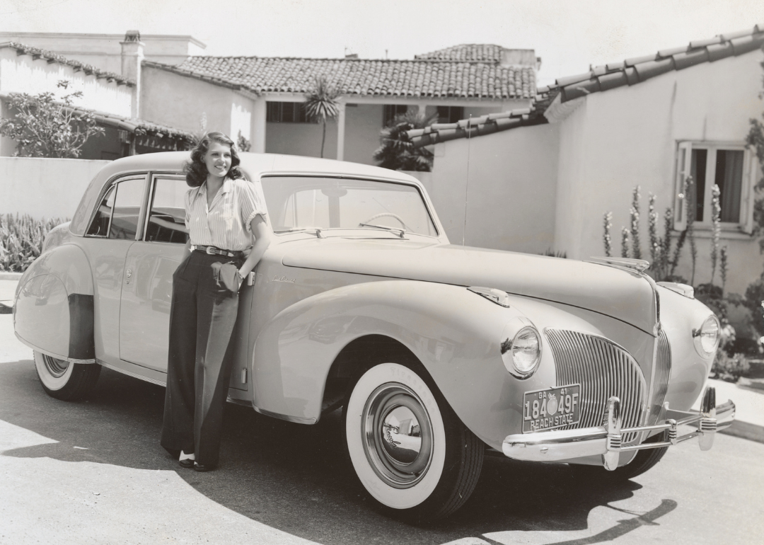Rita Hayworth in front of her bungalow with her new Lincoln Continental.