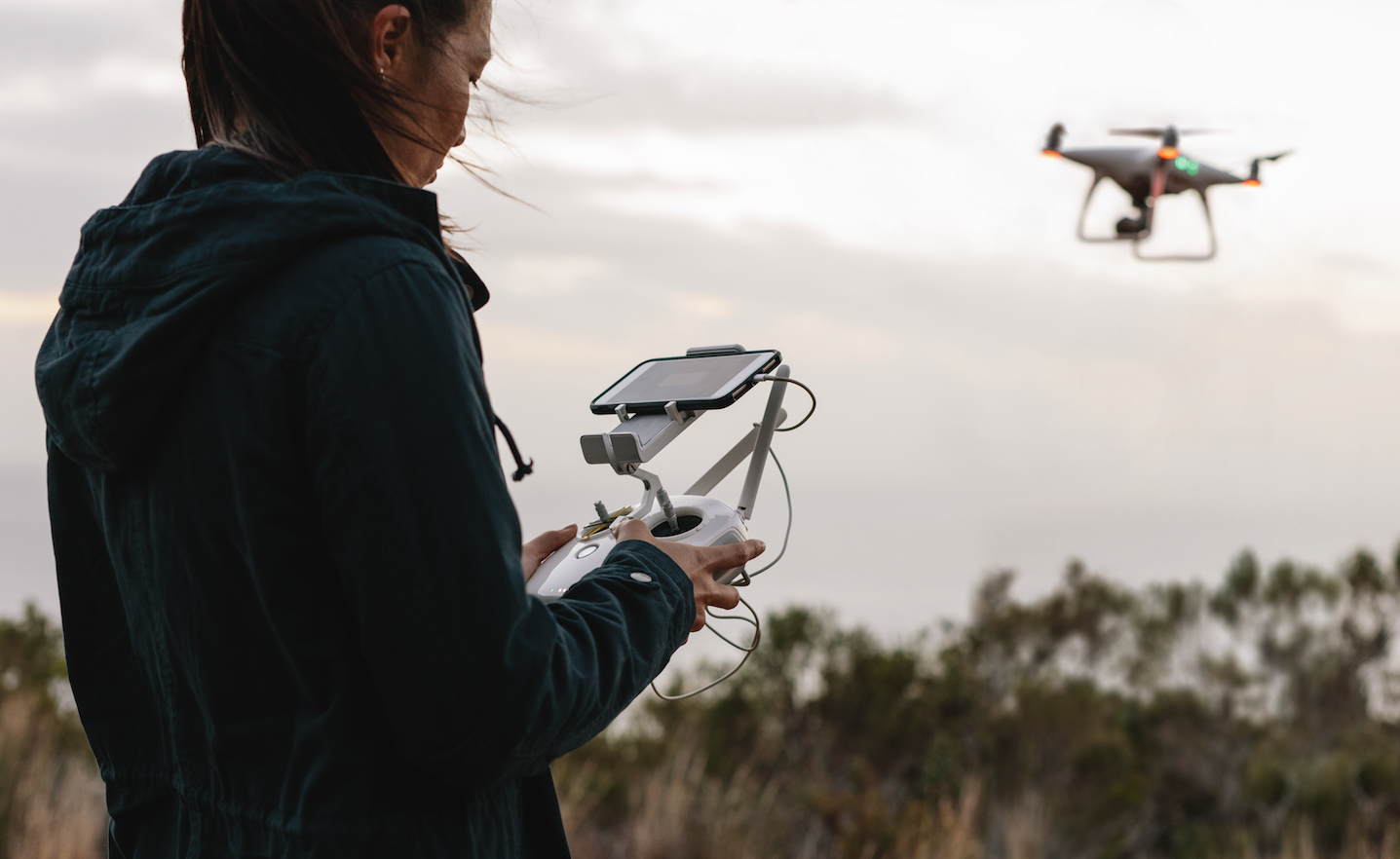 Управляющий квадрокоптером. Пилот бпла. Человек с квадрокоптером. Оператор беспилотных летательных систем. Человек управляет дроном.