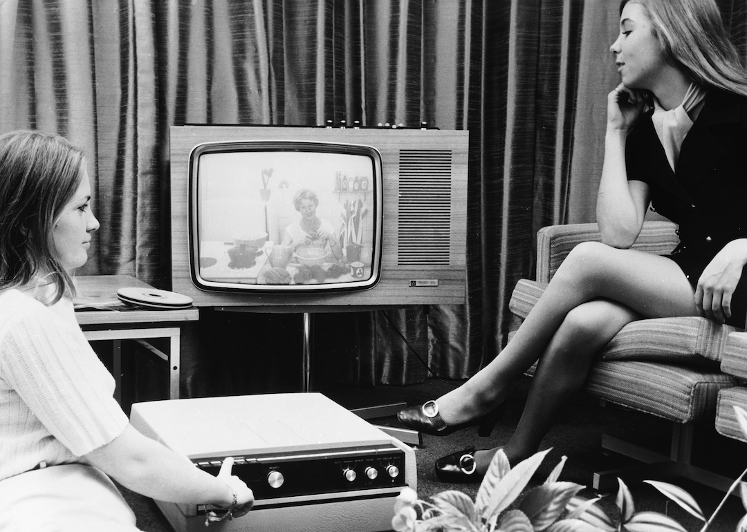 Two young women watching TV in the 1970s.