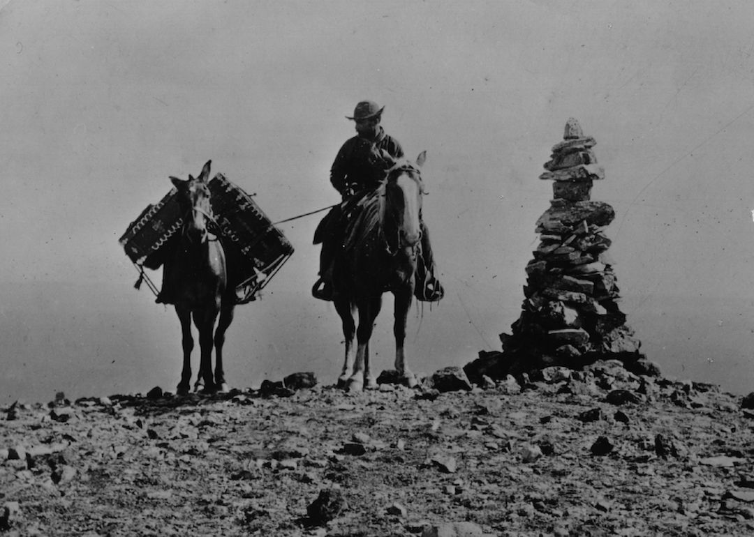 Photographer W H Jackson carrying his photographic equipment on horseback to the summit of Mount Washburn, Yellowstone National Park, circa 1870.