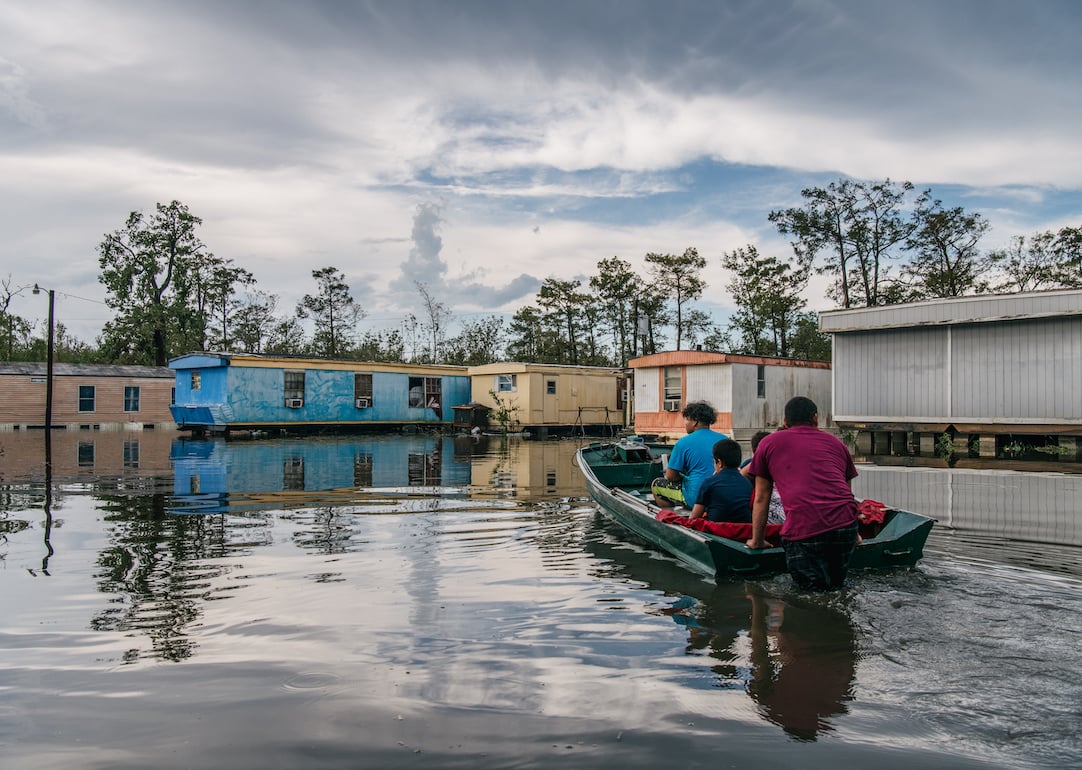 The Maldonado family travel by boat to their home after it flooded during Hurricane Ida on August 31, 2021 in Barataria, Louisiana