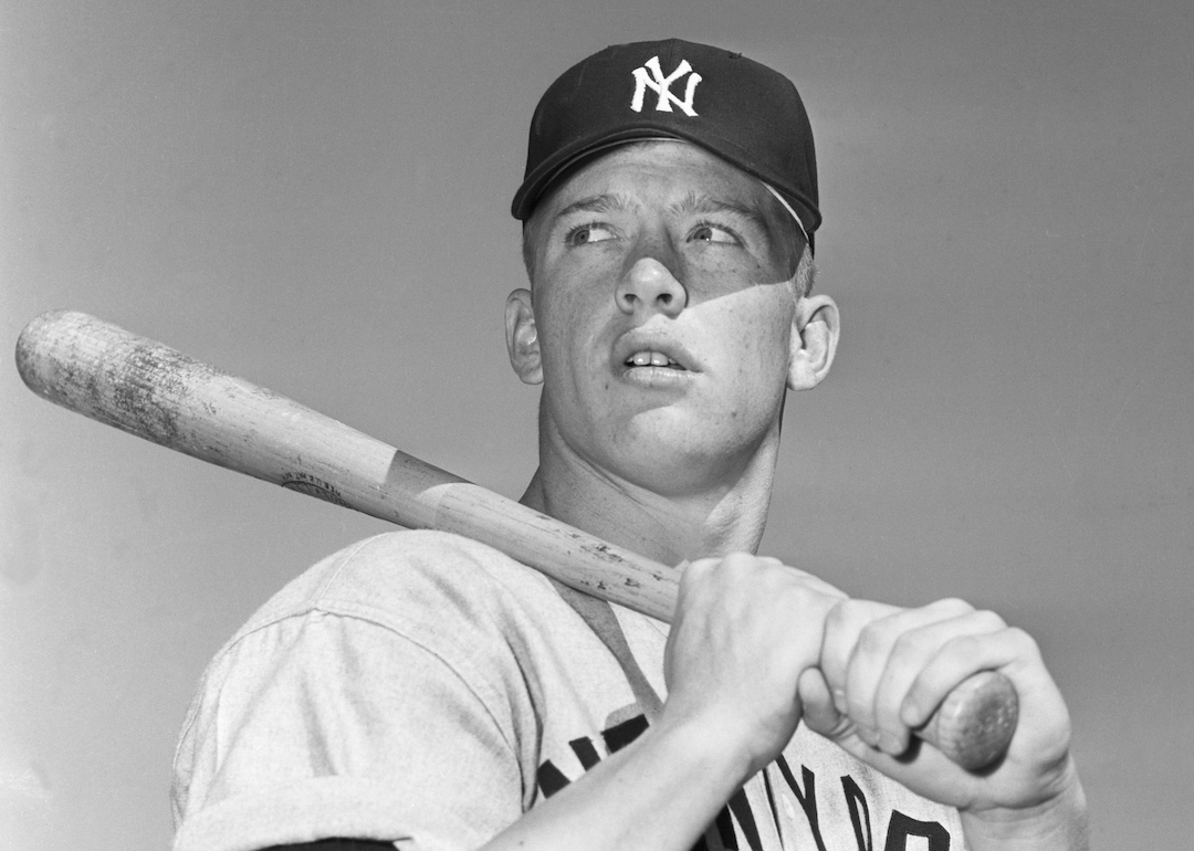 Mickey Mantle of the New York Yankees poses for a portrait with his baseball bat in 1951.