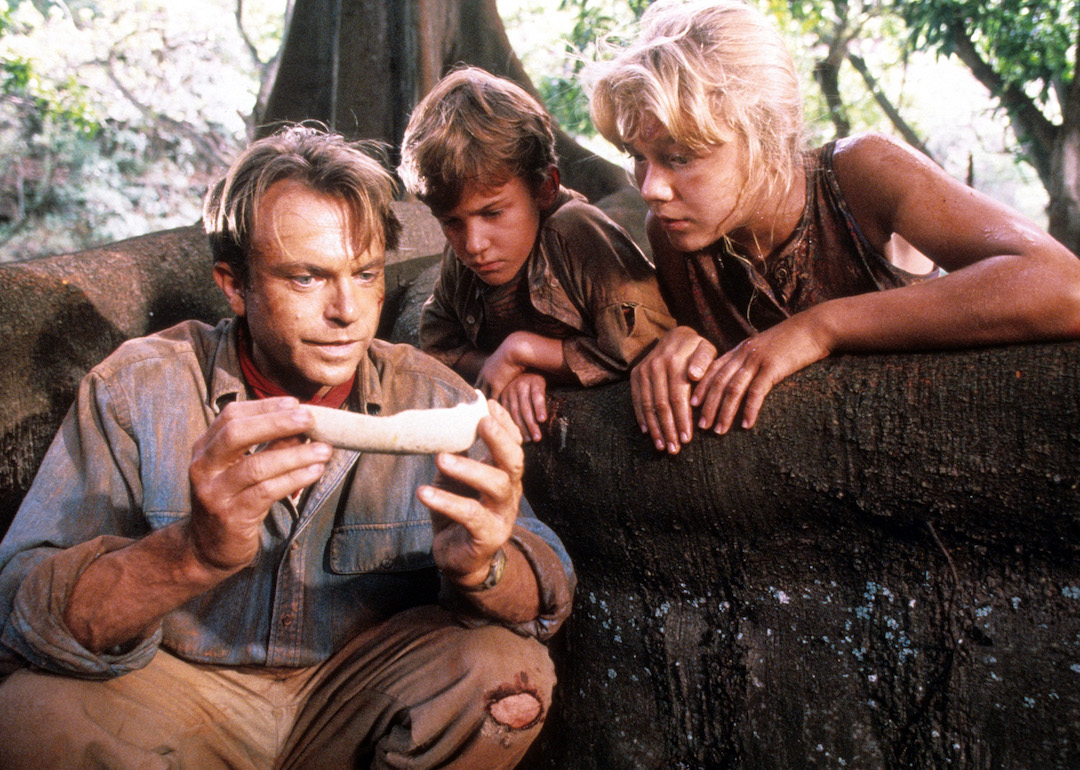 Actor Sam Neill shows a bone to child stars Joseph Mazzello and Ariana Richards in a scene from the 1993 film 'Jurassic Park.'