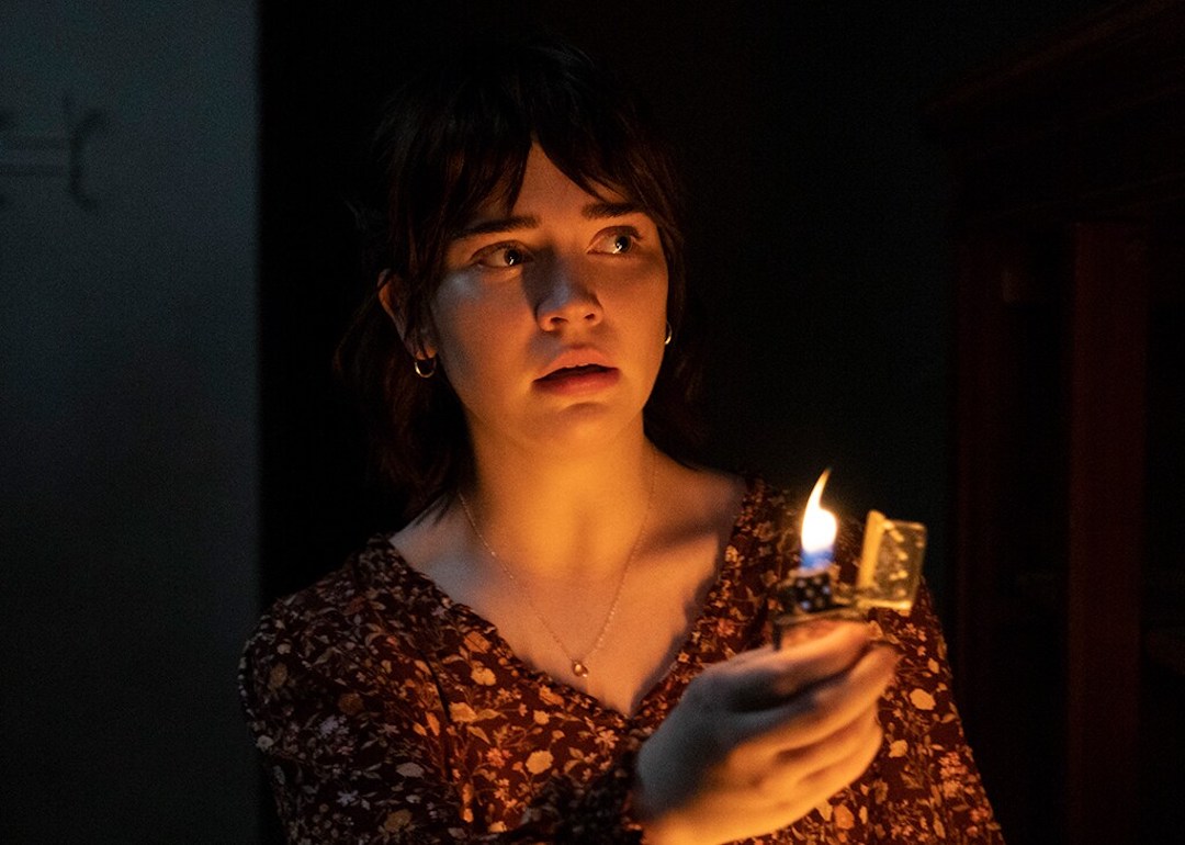 Actor Sophie Thatcher holds up a lighter in a dark room as Sadie Harper in the 2023 horror movie 'The Boogeyman.'