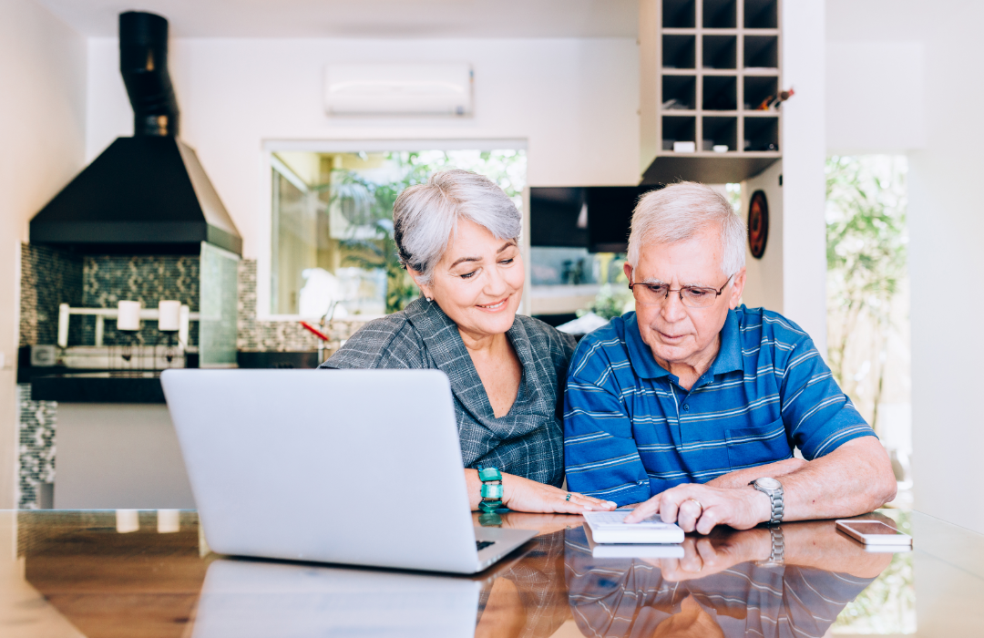 Senior couple in front of laptop looking over finances.