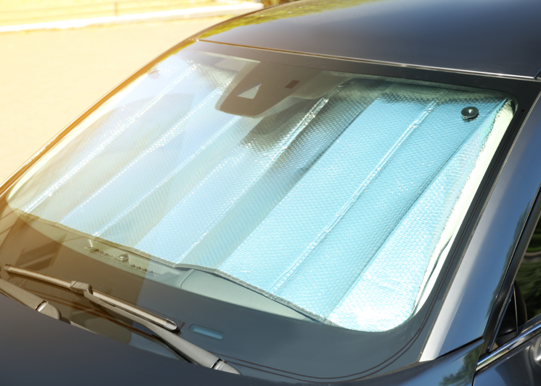 A reflective sun shield under the windshield of a car.