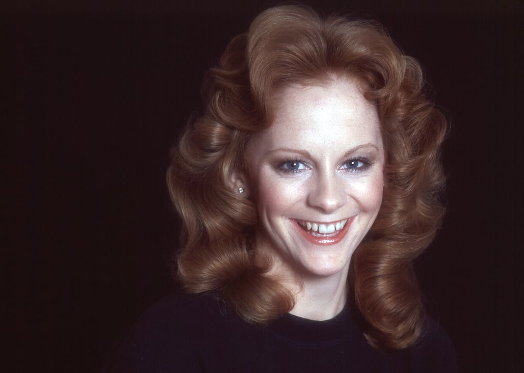 Portrait of Reba McEntire on a black background in 1960.