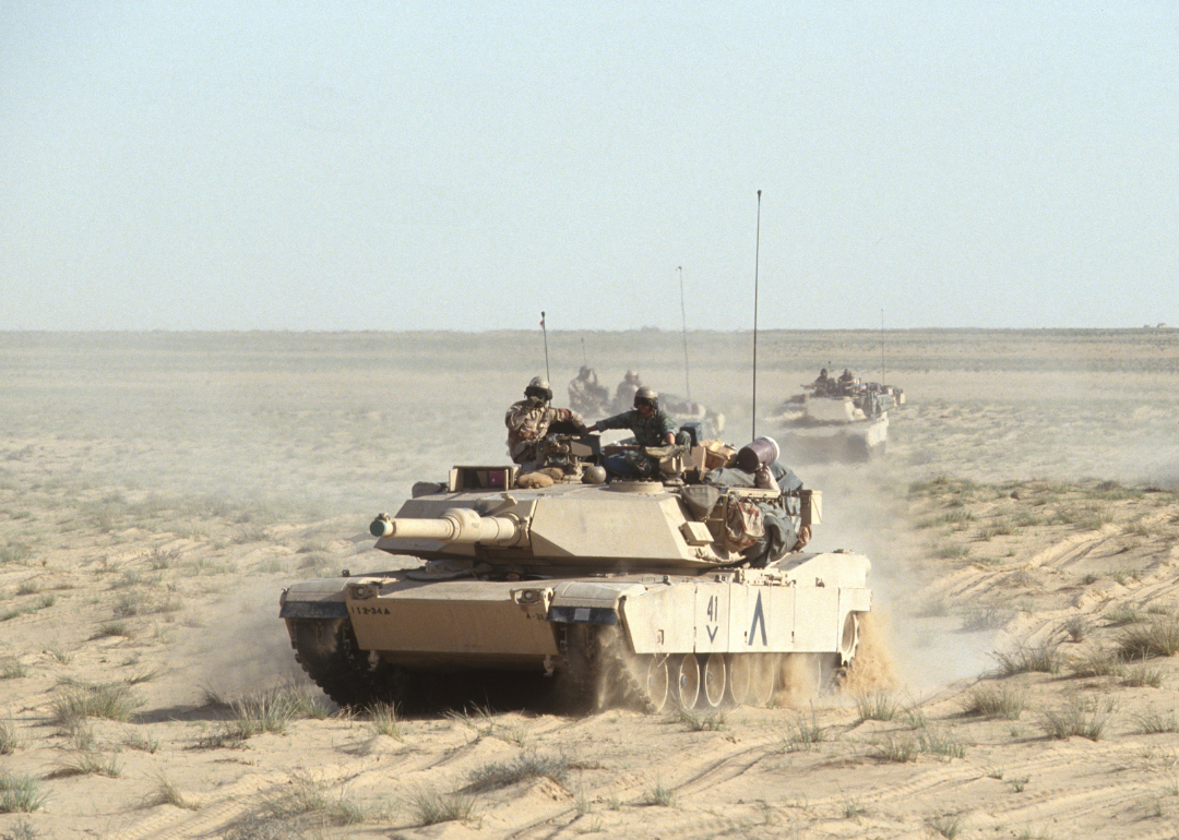 View of American M1A1 Abrams tanks as they cross the desert during the Gulf War, Iraq, 1991. 