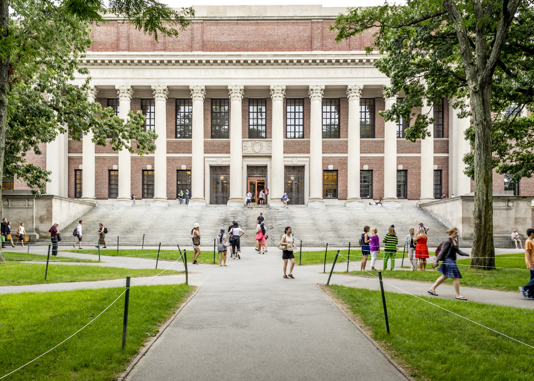 View of the campus of the famous Harvard University in Cambridge, Massachusetts, USA with some students, locals, and tourists passing by.