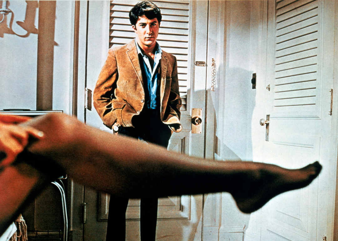 American actor Dustin Hoffman as Benjamin Braddock, watching his older lover Mrs Robinson get dressed in a promotional still from the film 'The Graduate', 1967.