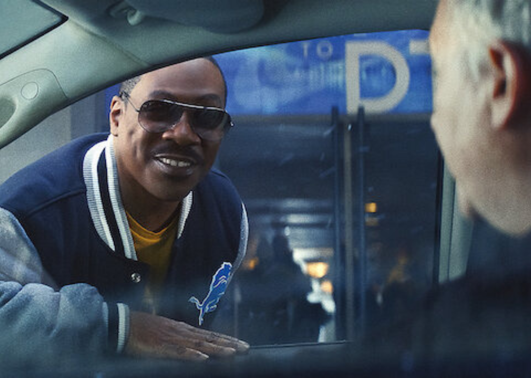 Eddie Murphy as Axel Foley leaning into a car window in a scene from 'Beverly Hills Cop: Axel F'