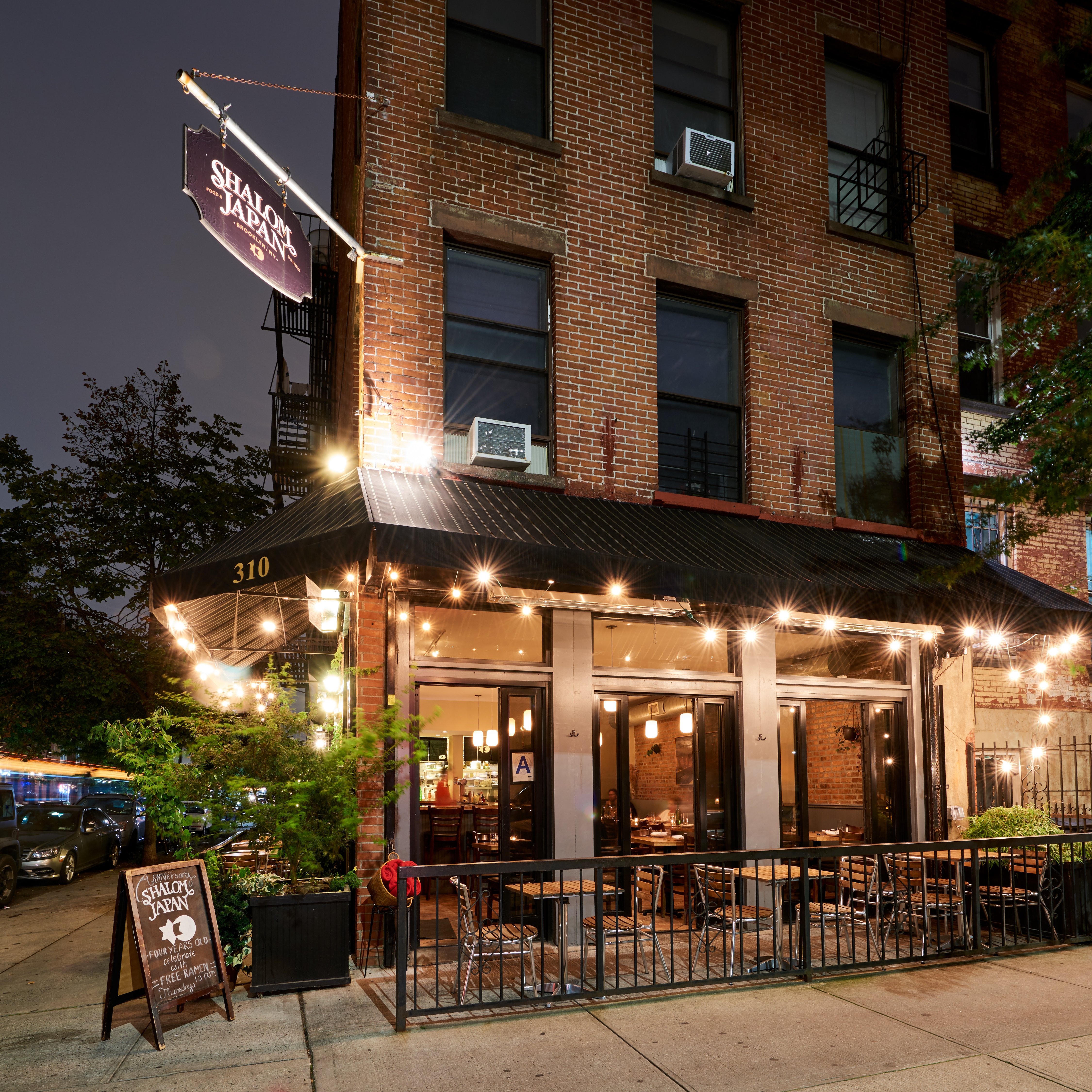 Full exterior of the Shalom Japan restaurant in Brooklyn, NY at night.