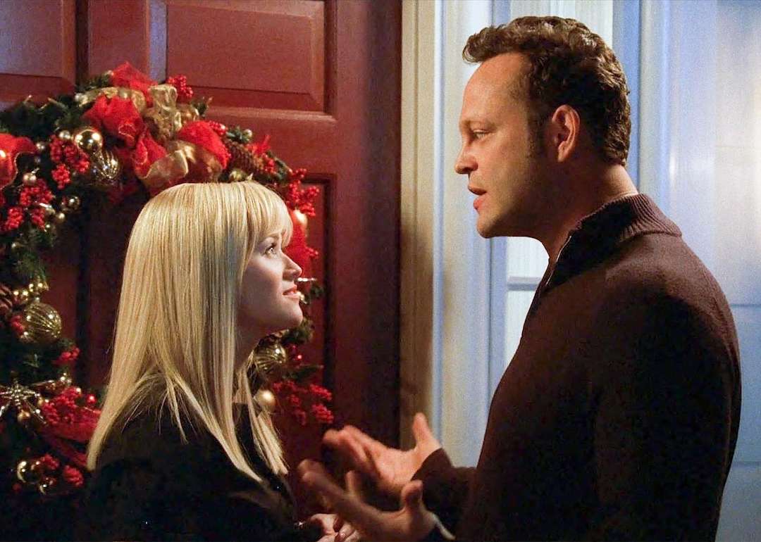 Reese Witherspoon and Vince Vaughn stand in front of a door with a wreath on it in the movie 'Four Christmases.'