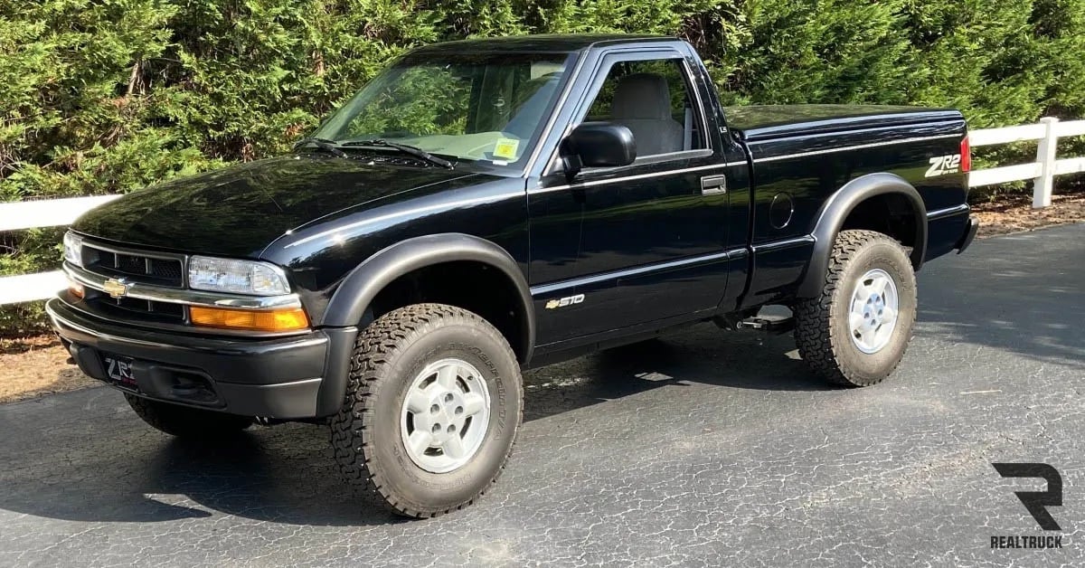 A black Chevy S10 parked on roadside.