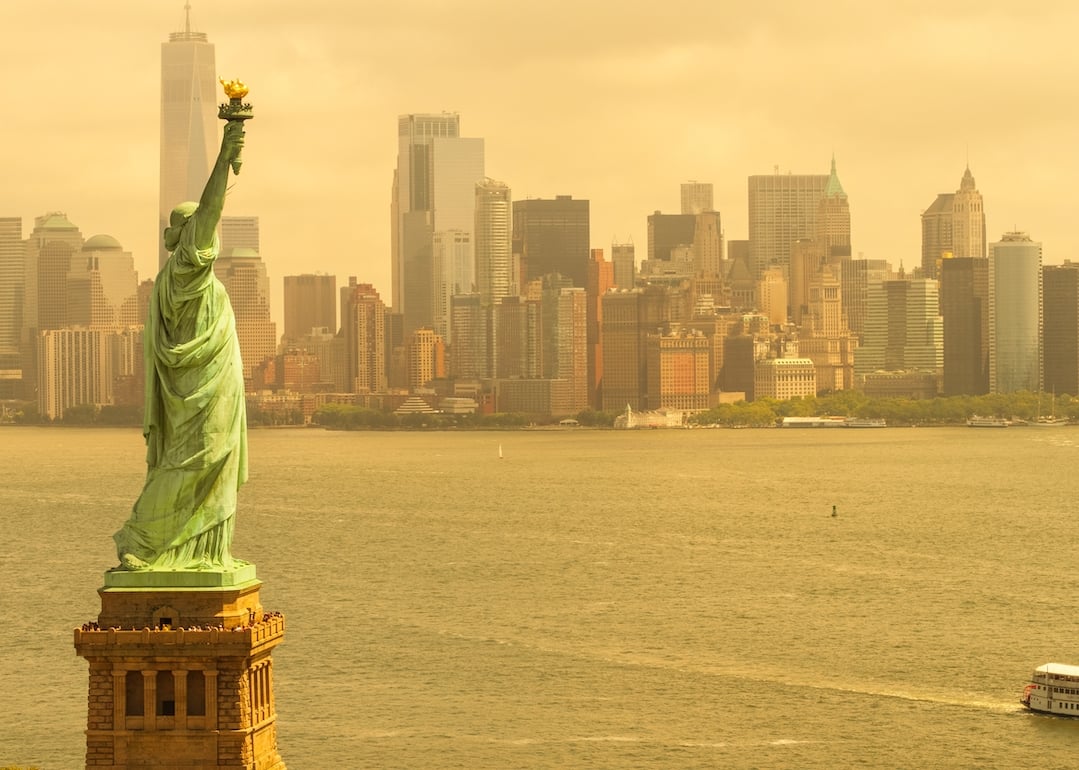 Humid day in New York City shows Statue of Liberty and skyline.