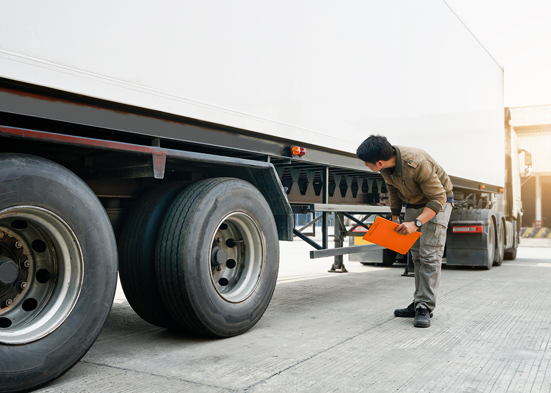 A mechanic inspecting a cargo truck for transport.