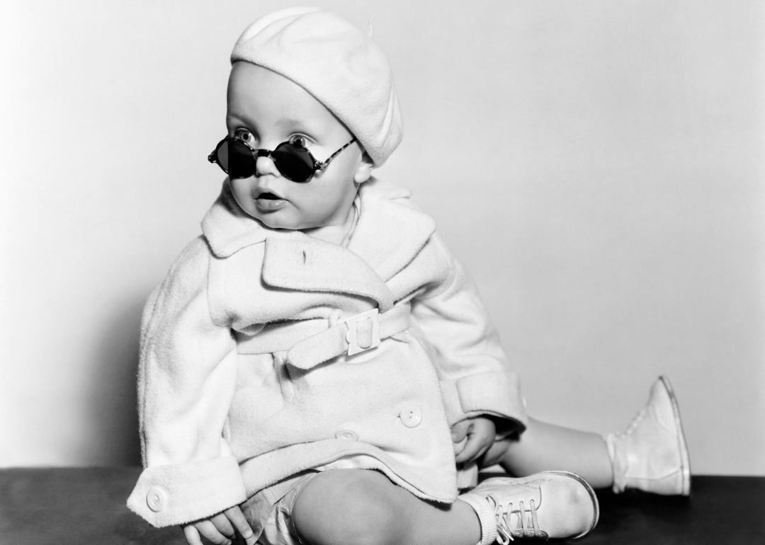 Vintage studio portrait of a baby wearing a beret and sunglasses
