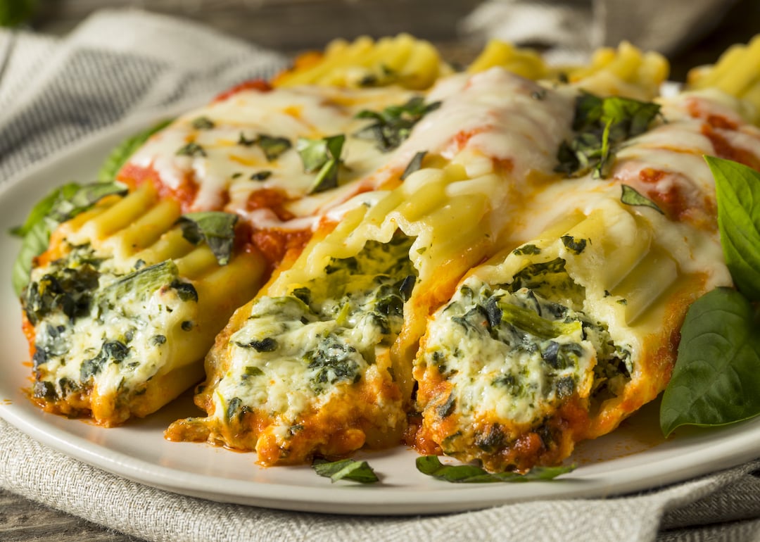 Homemade suffed ricotta and spinach manicotti with basil.