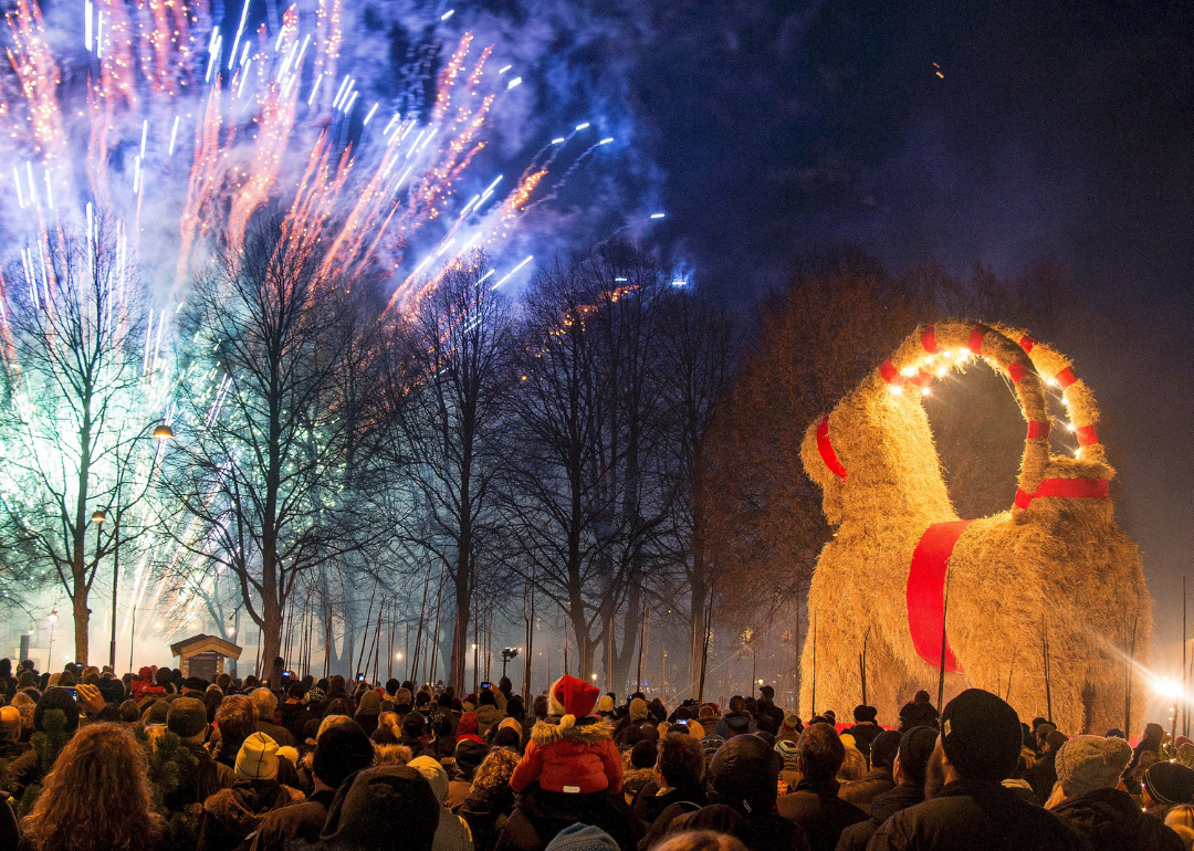People look at fireworks during the inauguration of the traditional Gävle Goat Goat in Gävle Goat, Sweden during Christmas. 