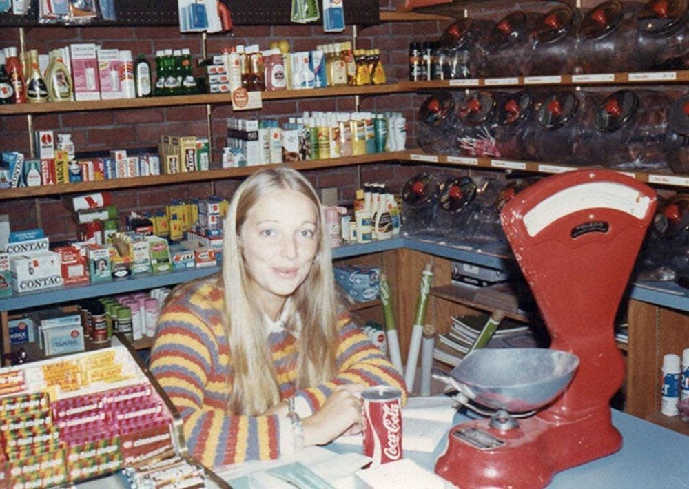 Woman wearing a striped swearing sitting behind the counter at a grocery store