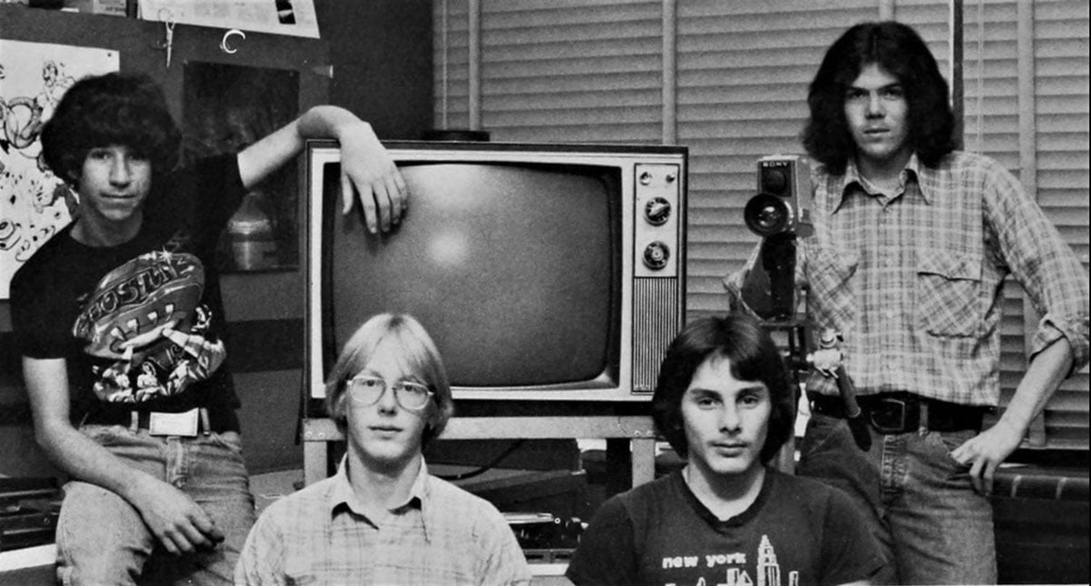 Four boys around a tv in a high school media lab
