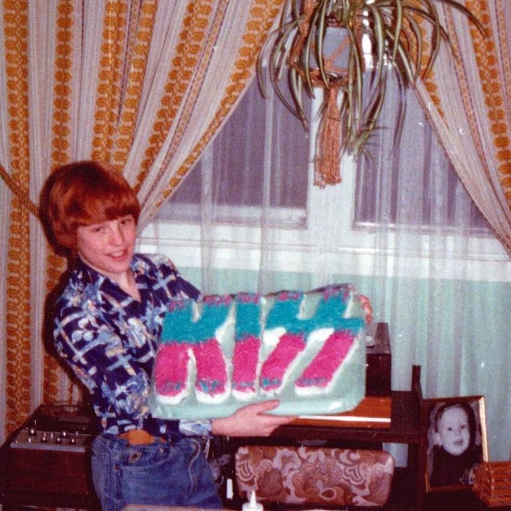 Teenager proudly holding up his KISS birthday cake