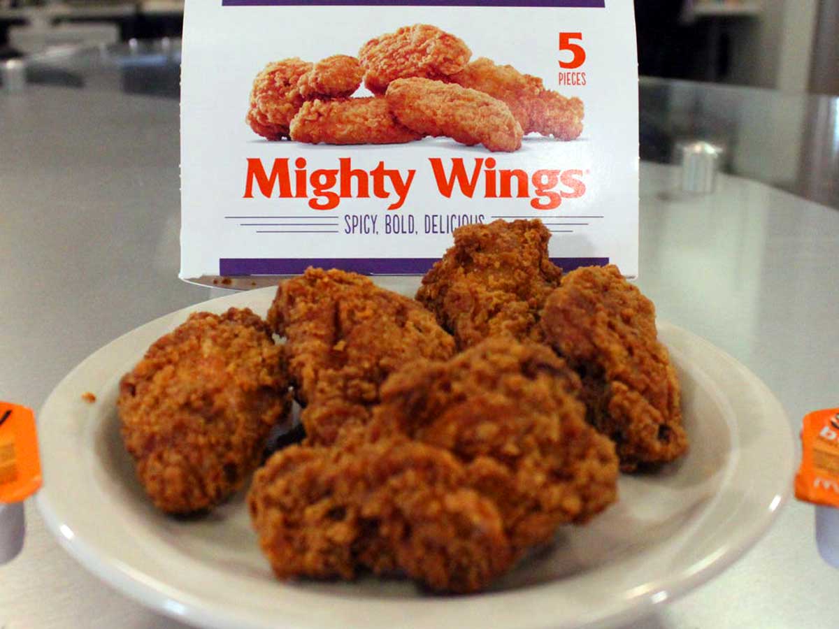 Some McDonald's Mighty Wings on a plate in front of the original packaging