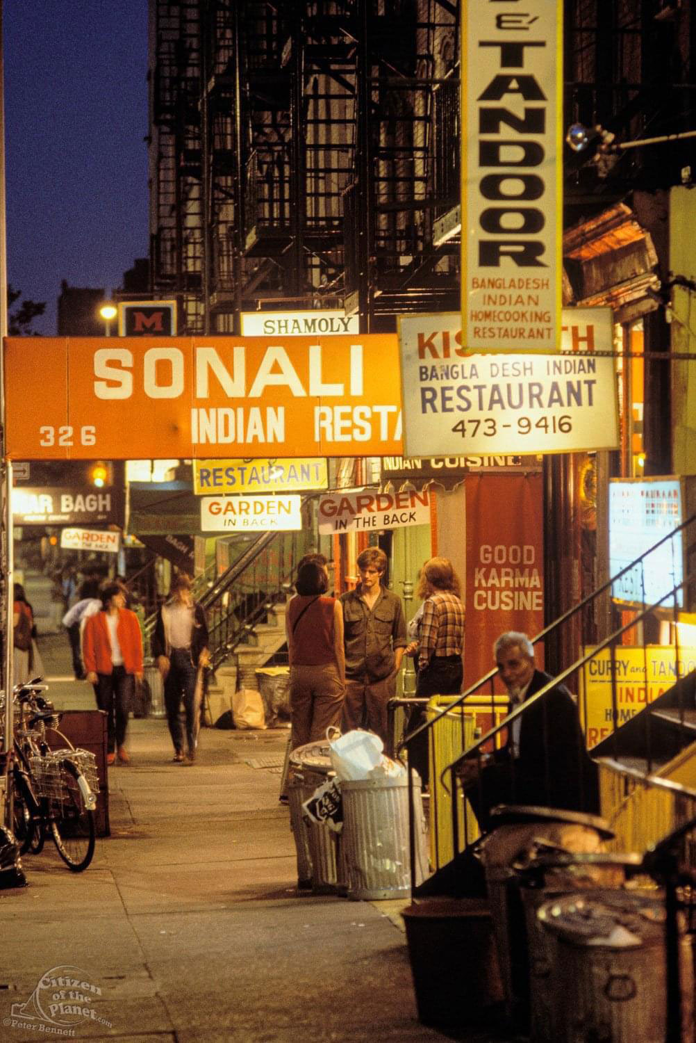 Some people sitting around on 6th street in NYC