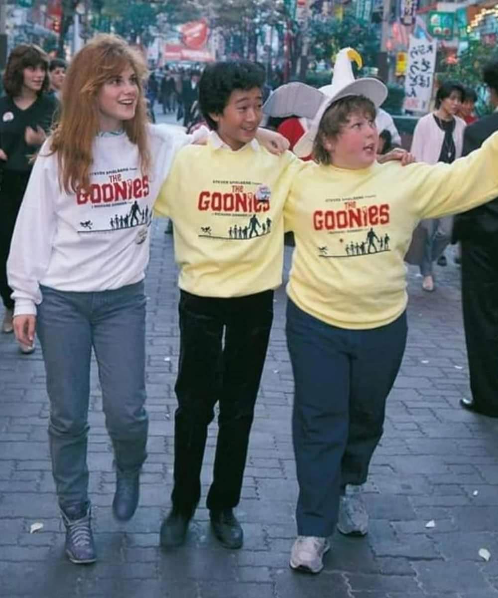 Three members of the Goonies cast wearing Goonies sweatshirts on the street