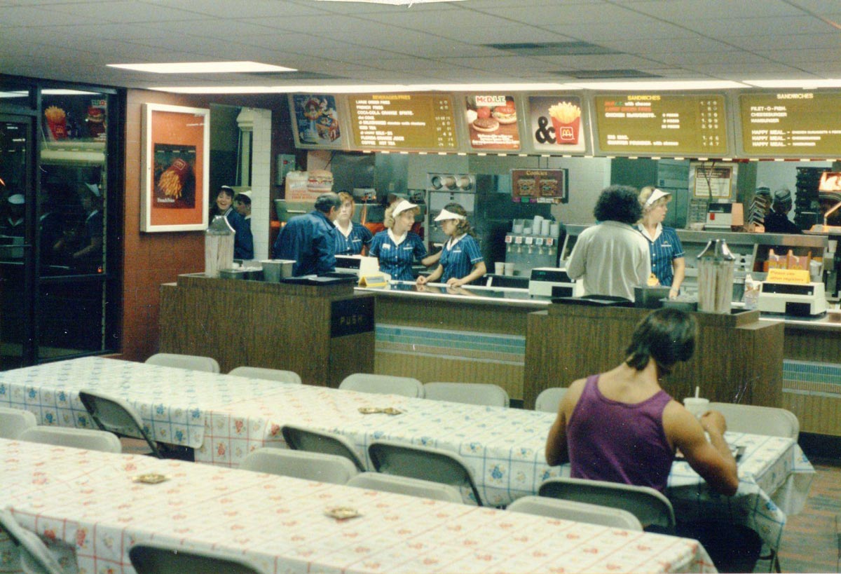 Interior shot of a McDonald's with long family style tables covered in vinyl tablecloth