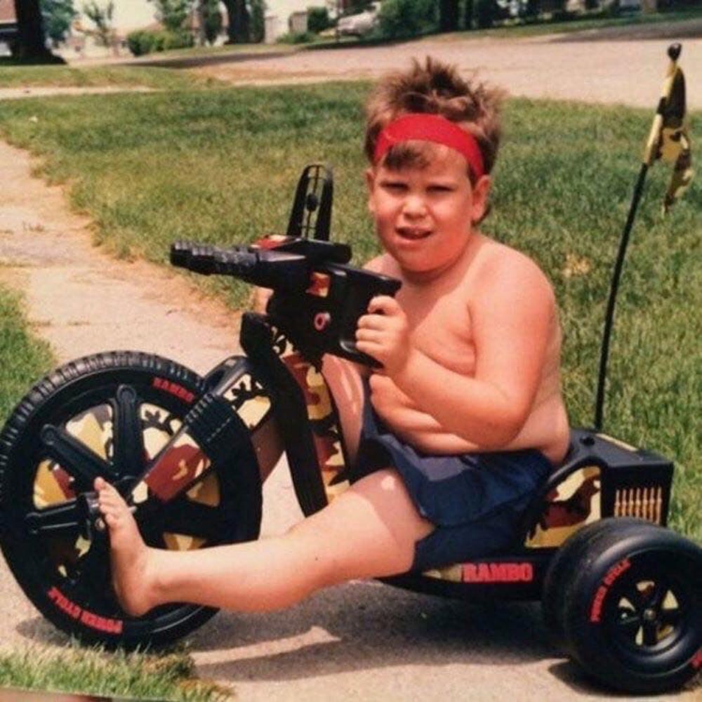 Kid with a red sweatband on a Rambo Big Wheel
