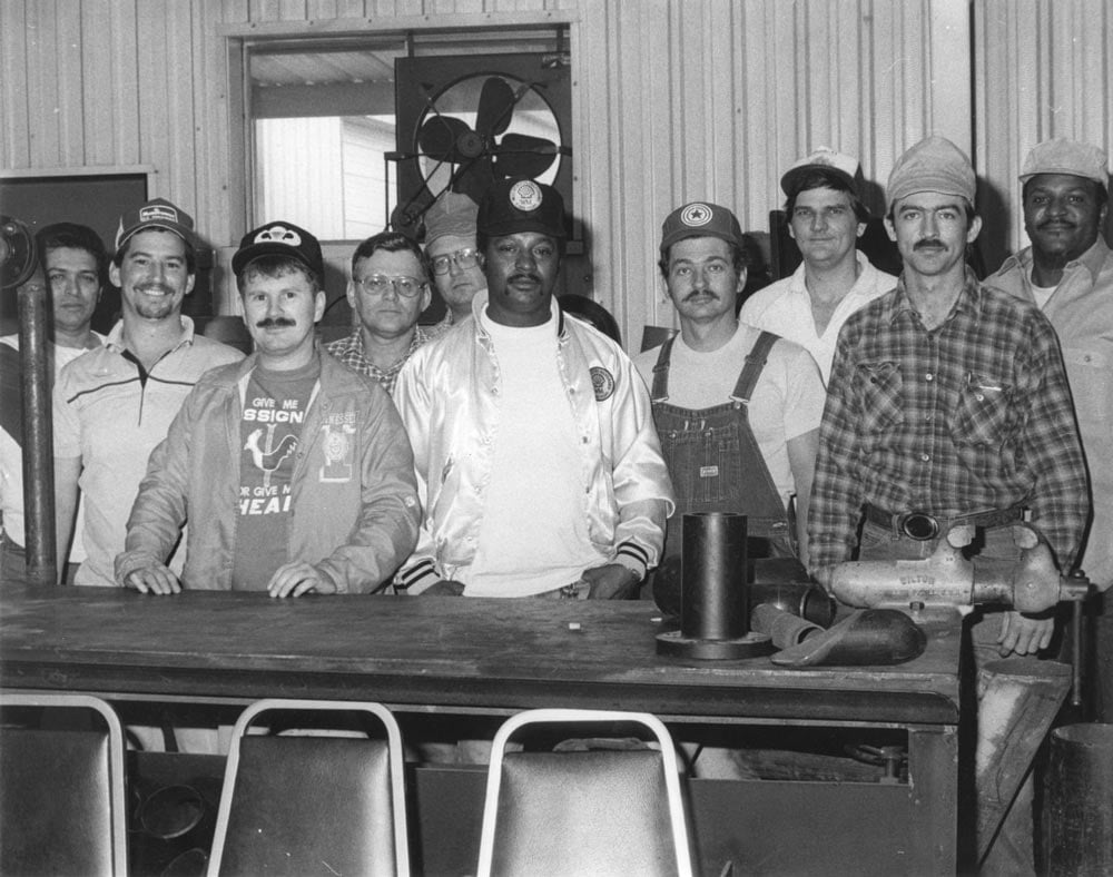 A group of men posing for a photo after graduation from welding school