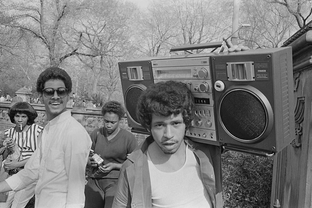 Young man hanging out in central park with a boombox on his shoulder in 1981