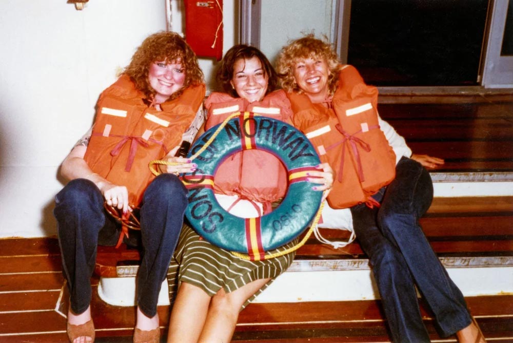 Three woman with life vests on pose for a photo