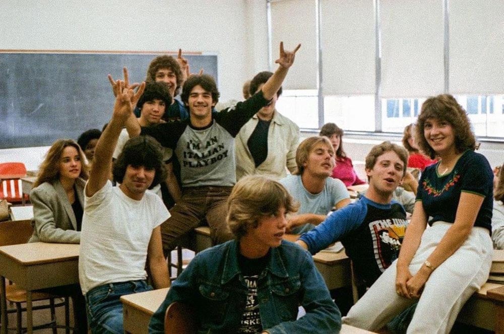 Kids sitting around in a classroom posing for the camera