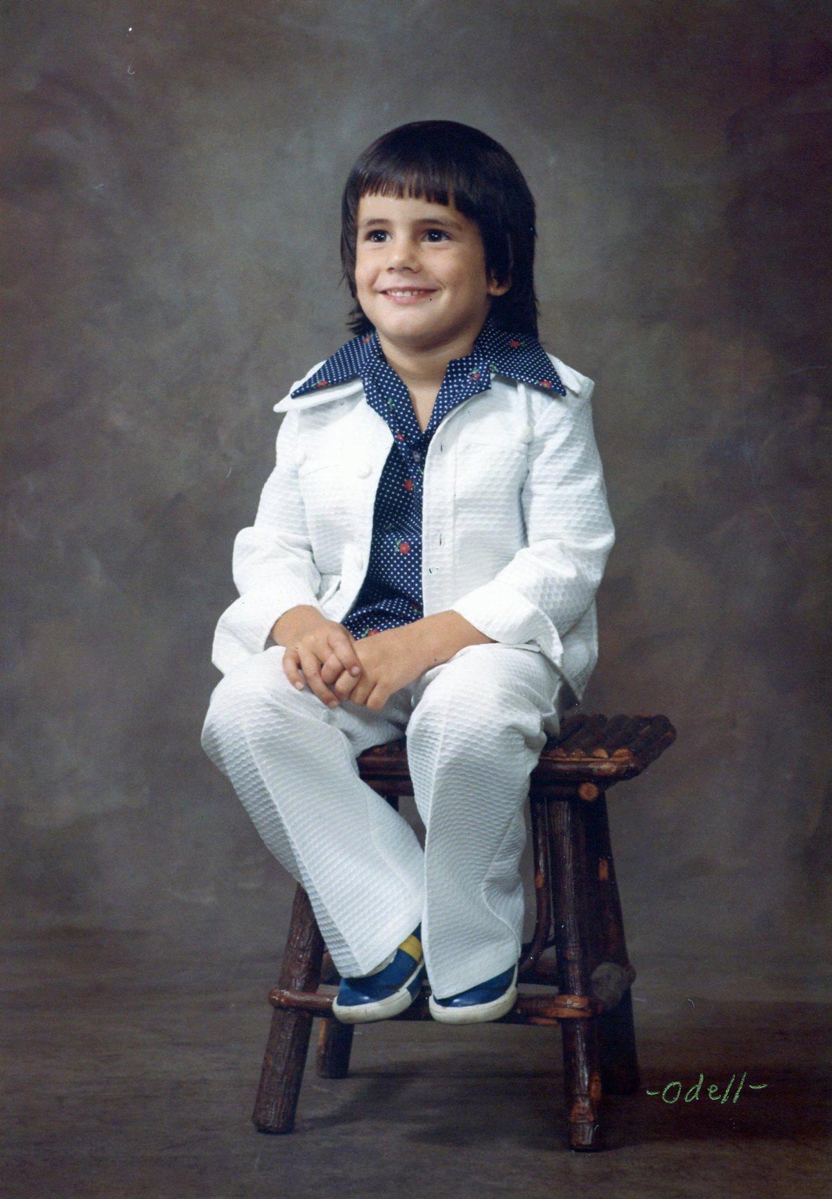 A kid in a very 1970s white suit for a school photo