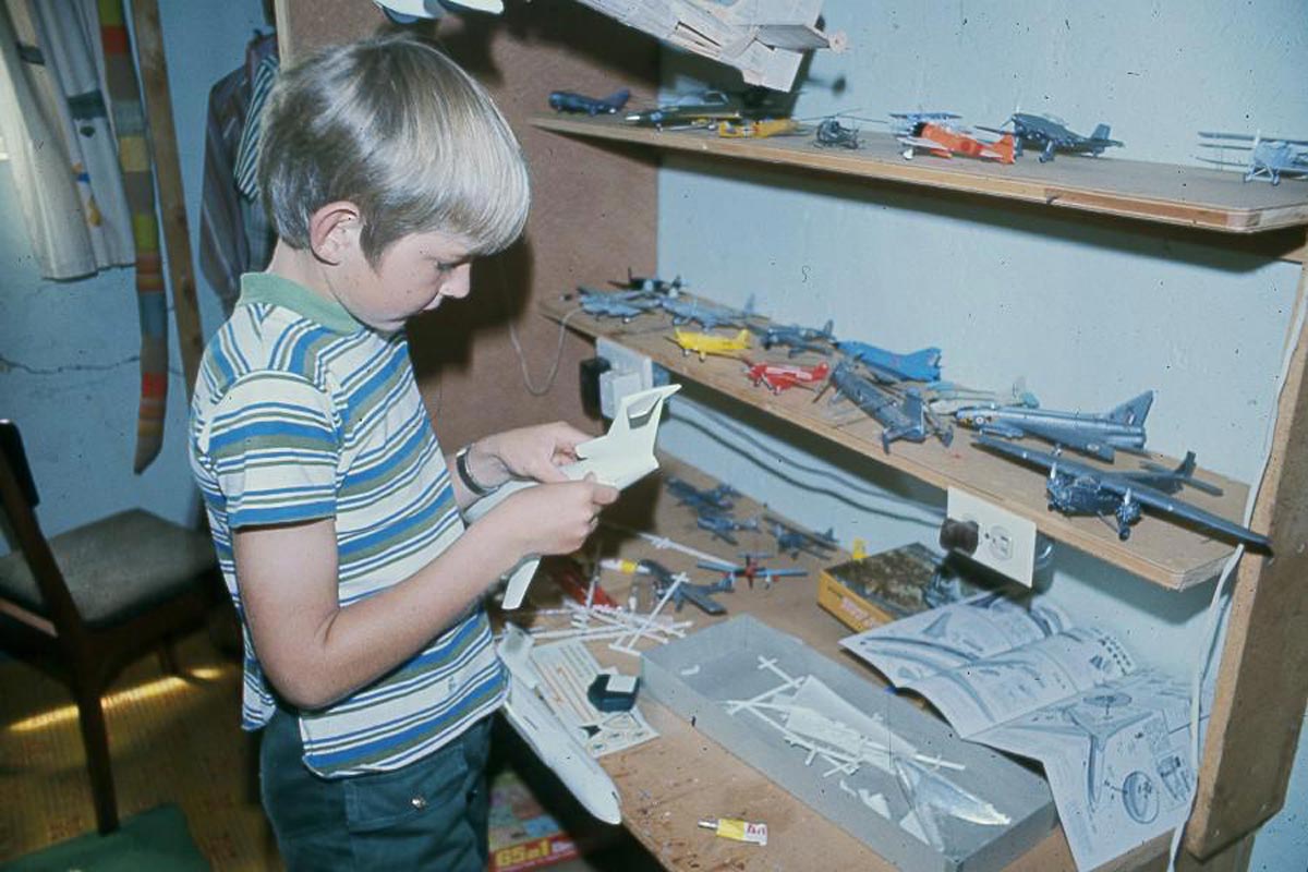 A boy putting together model planes