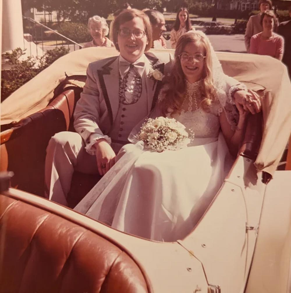 A couple on their wedding day sitting in the back of a Rolls Royce