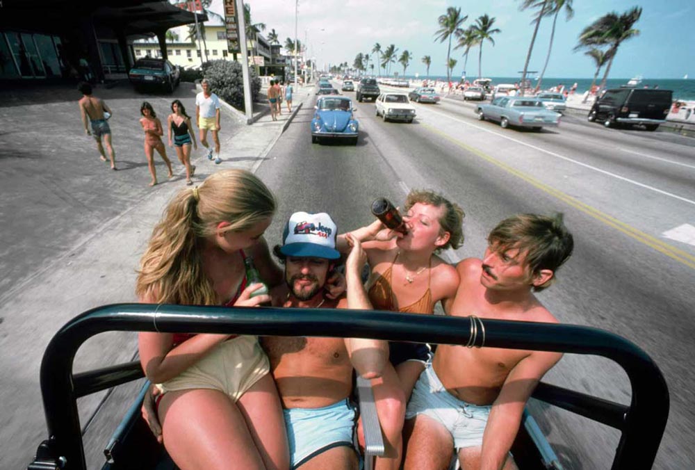 Four young people sitting in the back of a jeep 