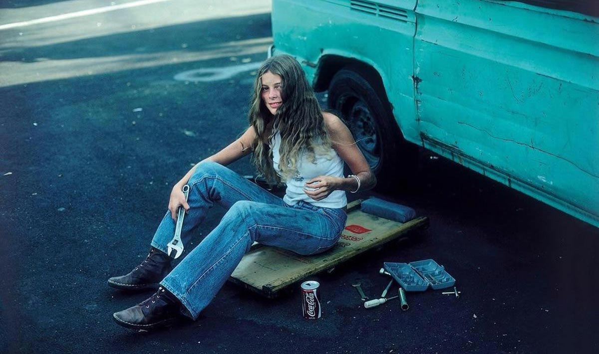 A woman taking a quick break from fixing her van to pose for a photo
