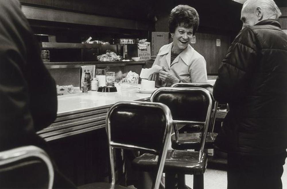 Black and white photo of a waitress laughing