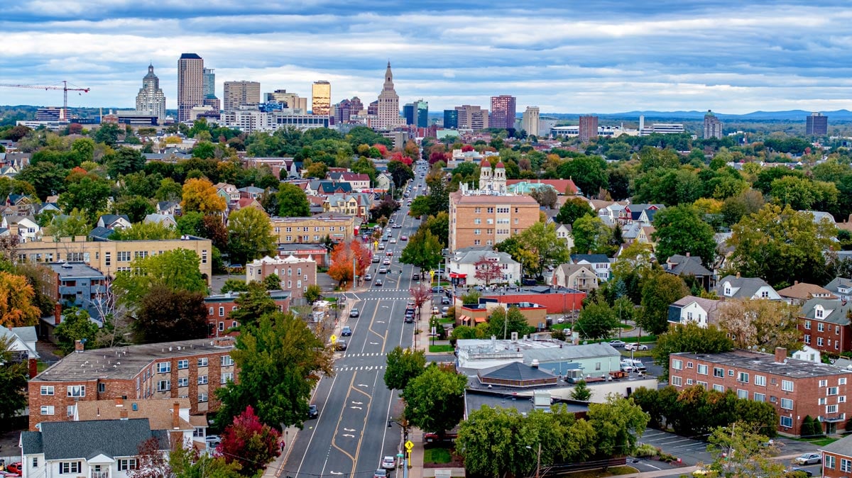 Hartford Connecticut aerial image. Drone image of CT's capital from a mile away, showing a main strip leading into the city with the tall buildings against a gorgeous cloudy sky.