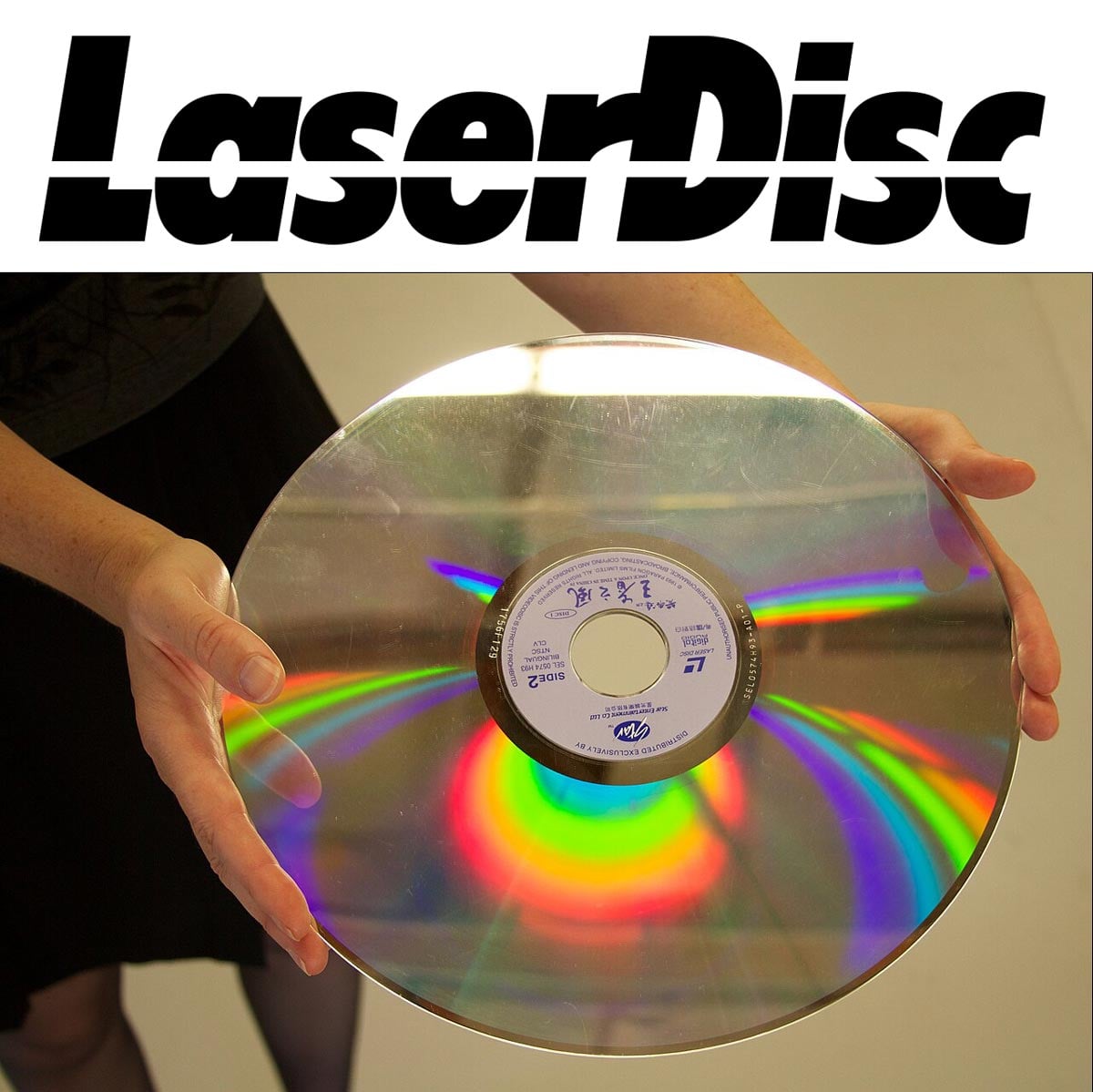 Laser disc logo and a photo of someone holding a laserdisc