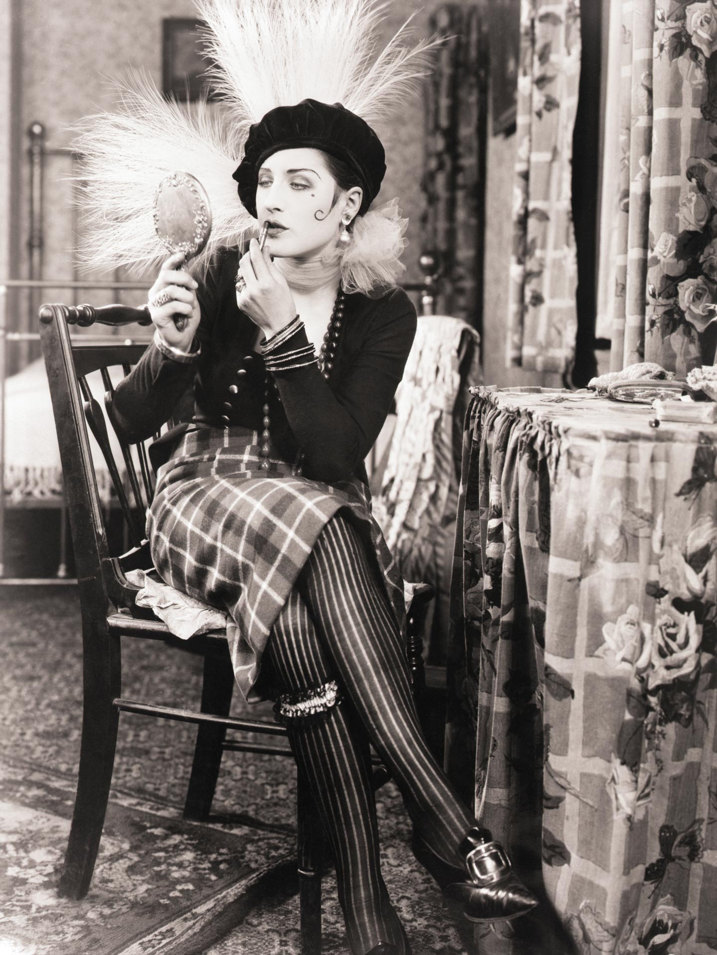 Norma Shearer in a scene from the 1925 Metro-Goldwyn silent, "Lady of the Night." She is seated at her dressing table applying lipstick.