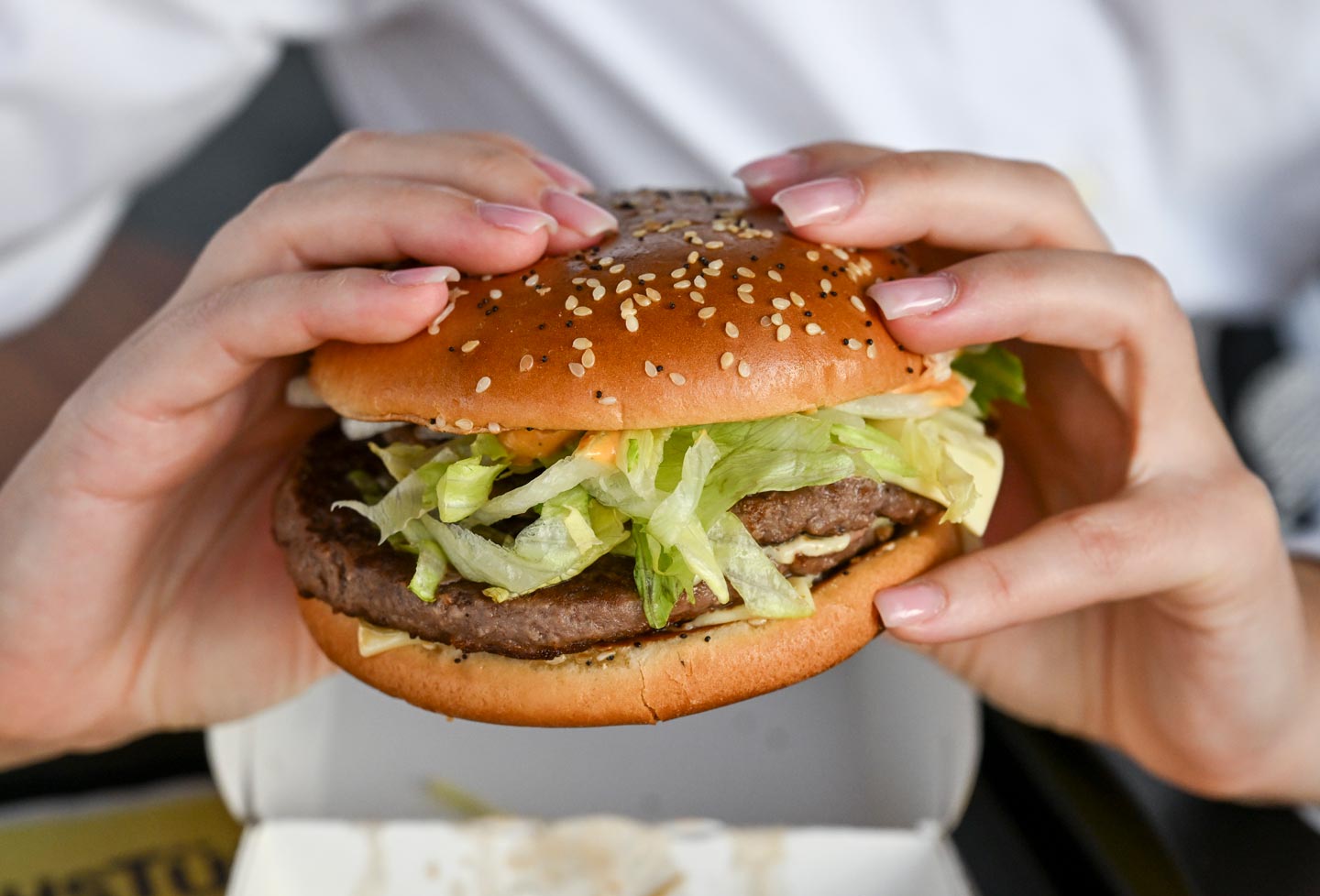 A woman holding a burger in her hands.