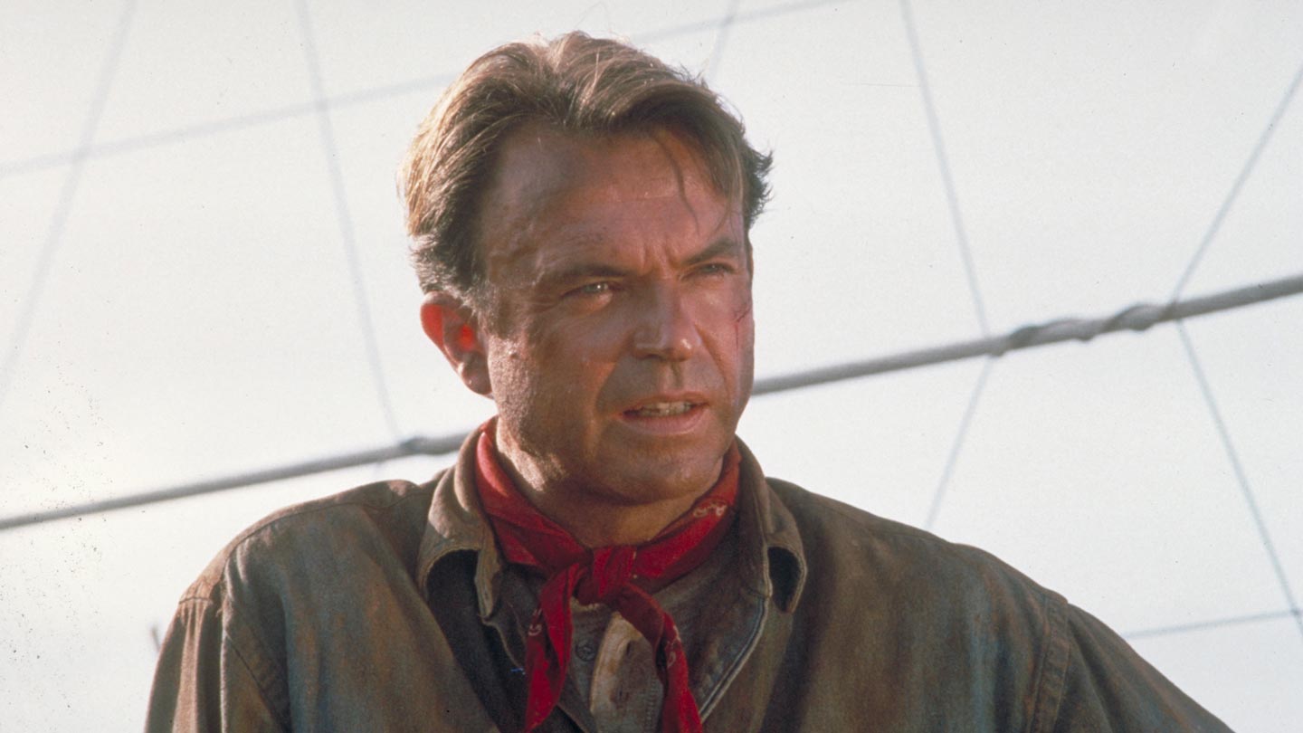 Actor Sam Neill as Dr. Alan Grant, next to an electric fence in a scene from the film 'Jurassic Park', 1993.