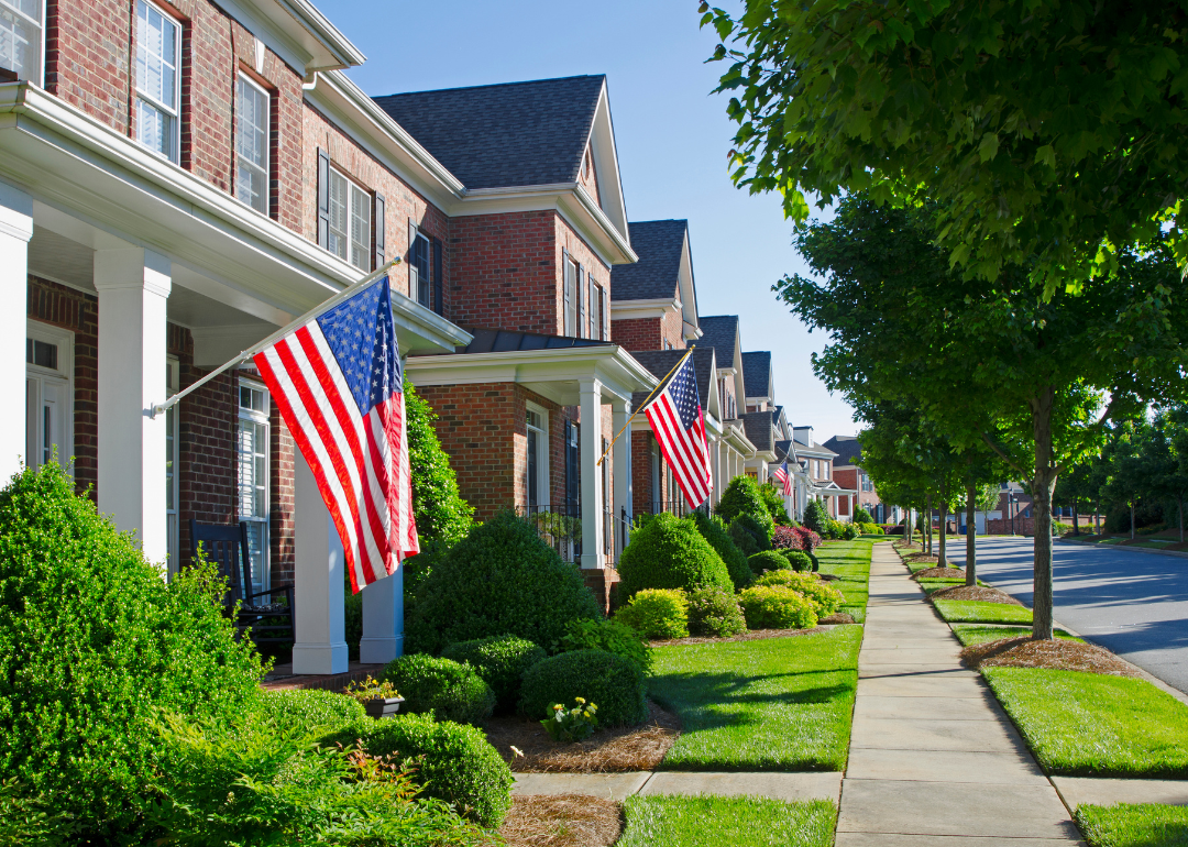 A neighborhood of brick homes with American flags.