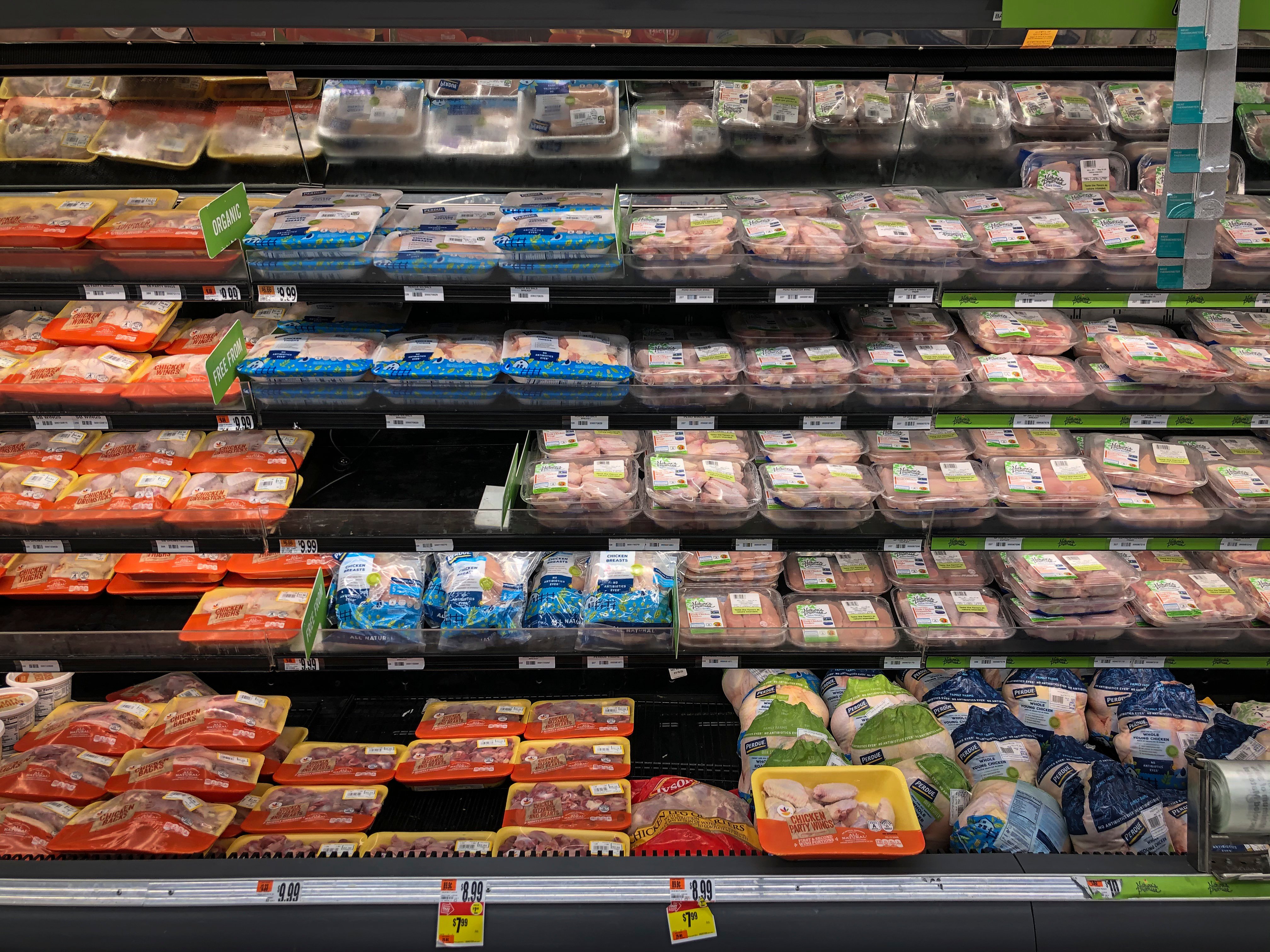 Rows of meat in a cold case at a grocery store.