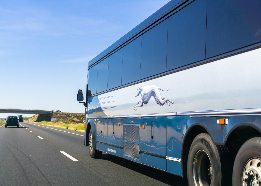 A Greyhound bus driving on a highway in Los Banos, California.